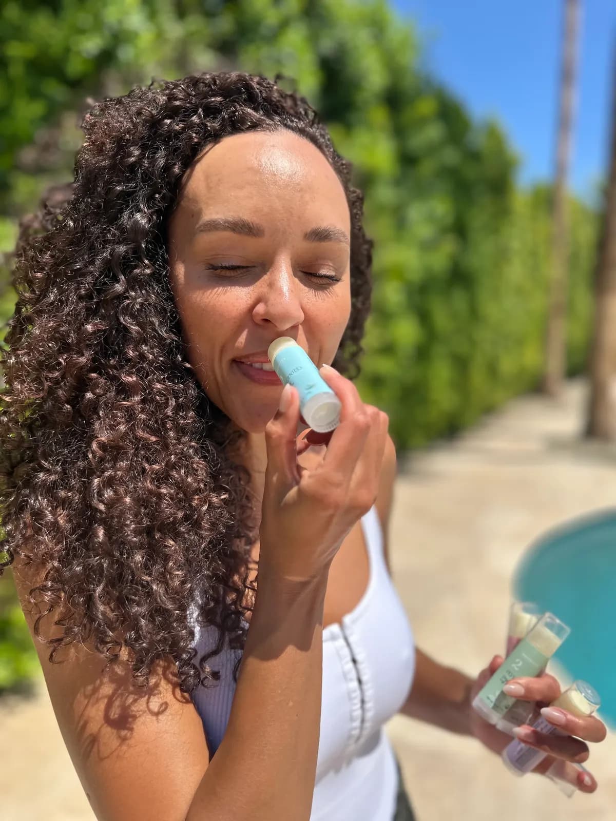 Applying Numbrrrz organic lip balm poolside — just 4 ingredients